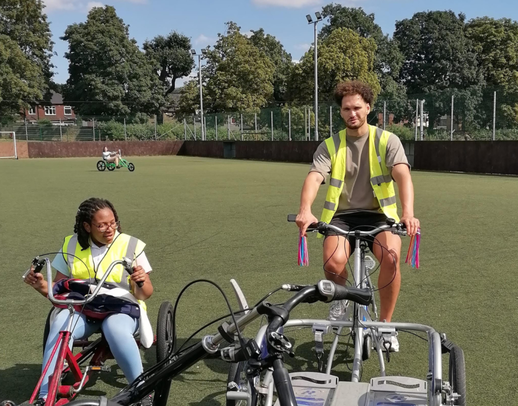 Two individuals on bicycles enjoy a sunny day in a field