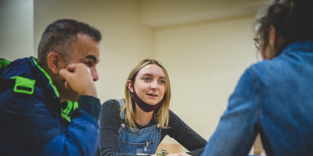 A group of people conversing at a table, illustrating a friendly exchange of thoughts and ideas in a relaxed setting.