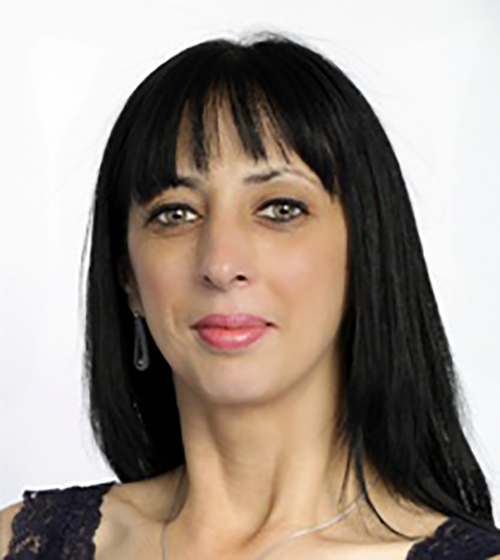 A woman with long black hair wearing a stylish black lace top, exuding elegance and confidence.